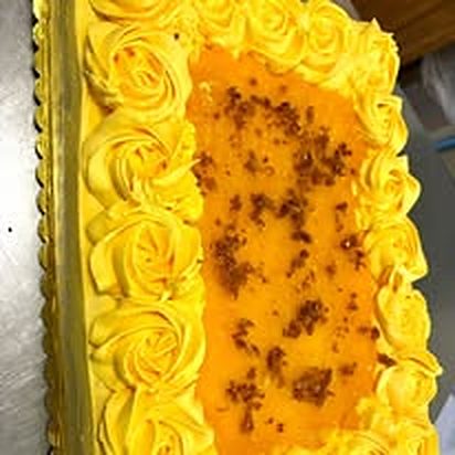 Sheet cake edged with yellow piped rosettes