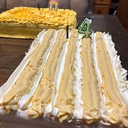 Celebration cake with piped stripes and a number candle