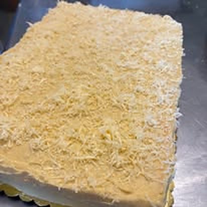 Sheet cake topped with grated cheese